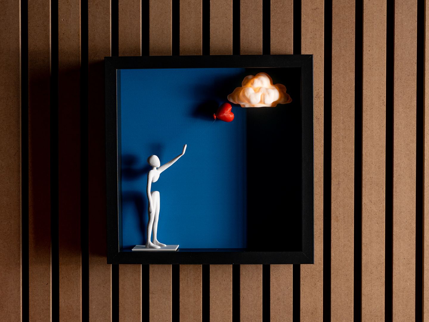 3D-gedruckte Figur mit herzförmigem Luftballon in einem Schattenbox-Wandbild