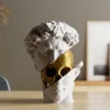 Klassische Büstenfigur mit Blick auf ein goldenes Skelett darunter, PrintHero