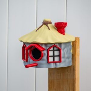 Bunt bemaltes Vogelhaus mit rundem Strohdach und roten Fensterrahmen, PrintHero